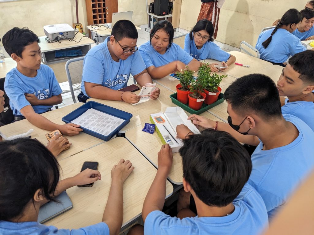 Students at SMP Sekolah Menengah Pertama Negeri 3 figuring out instructions for the soil sensor to measure soil pH–PXL 20250717 022711929.MP