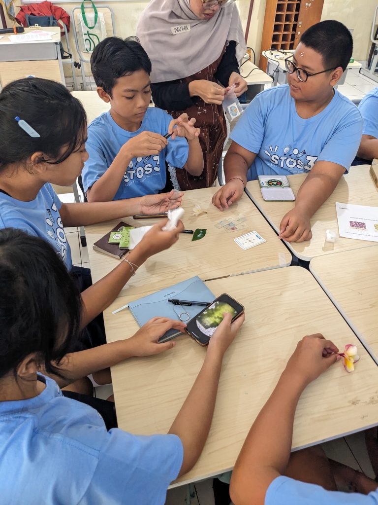 Students at SMP Sekolah Menengah Pertama Negeri 3 trying the Foldscope to examine microscopic samples–PXL 20250717 021359248.MP