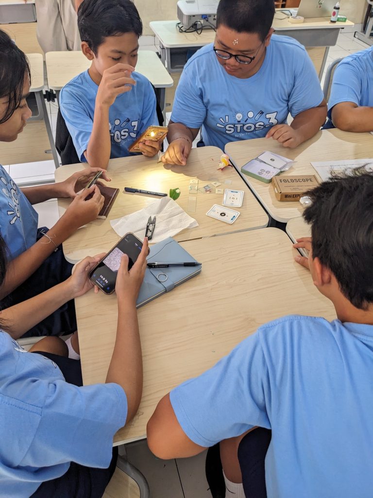 Students at SMP Sekolah Menengah Pertama Negeri 3 trying the Foldscope to examine microscopic samples–PXL 20250717 021640153.MP